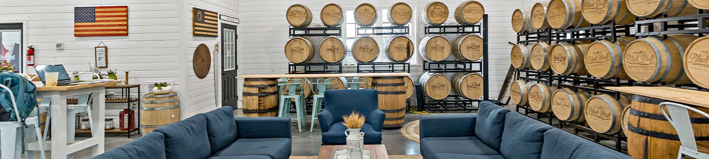 seating area and burbon barels inside black draft distillery in berkeley county, wv